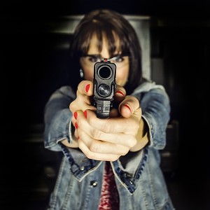 A young woman points a semi-automatic handgun downrange.