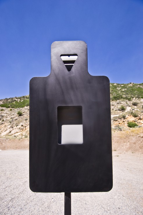 TacticalTorso2 Metal target stands outdoors; rectangular cutout; rocky landscape and clear sky background.