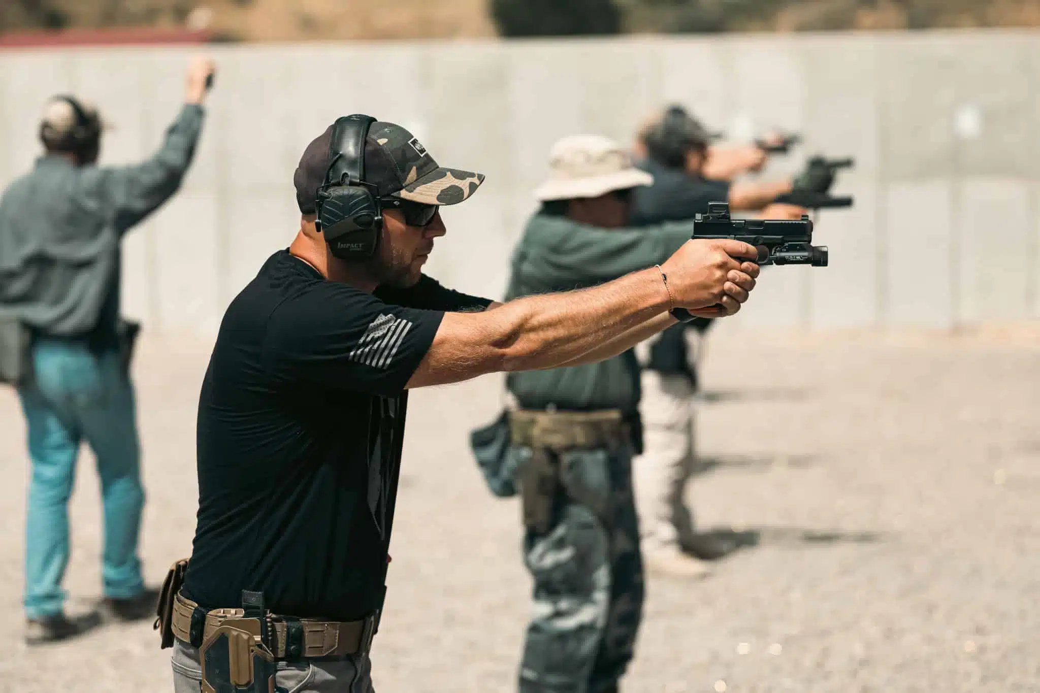 Line of officers shooting their pistols outside while at LETC